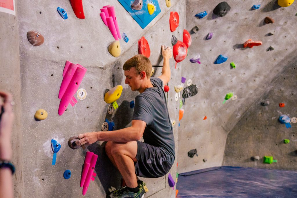 Student bouldering at the Kaplan Wellness Center.